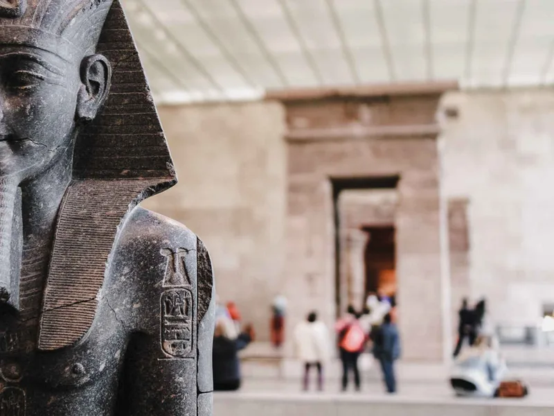 Visitors beside the Temple of Dendur inside the Metropolitan Museum of Art in New York