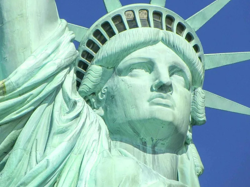 The Statue of Liberty seen from the official ferry, with Ellis Island Immigration Museum nearby in New York